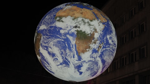 a large blue and white globe hanging from the side of a building