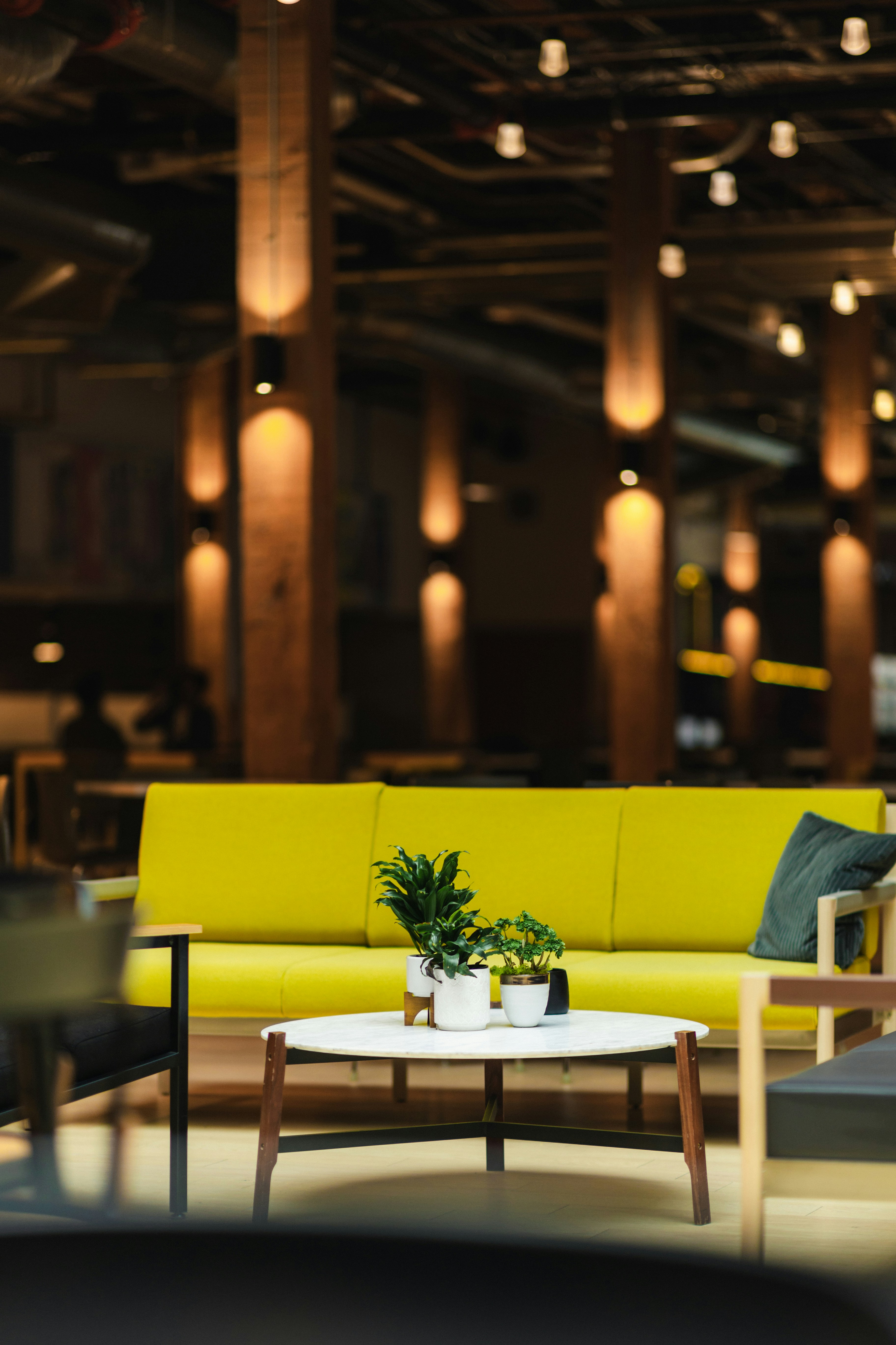 a yellow couch sitting in a living room next to a table