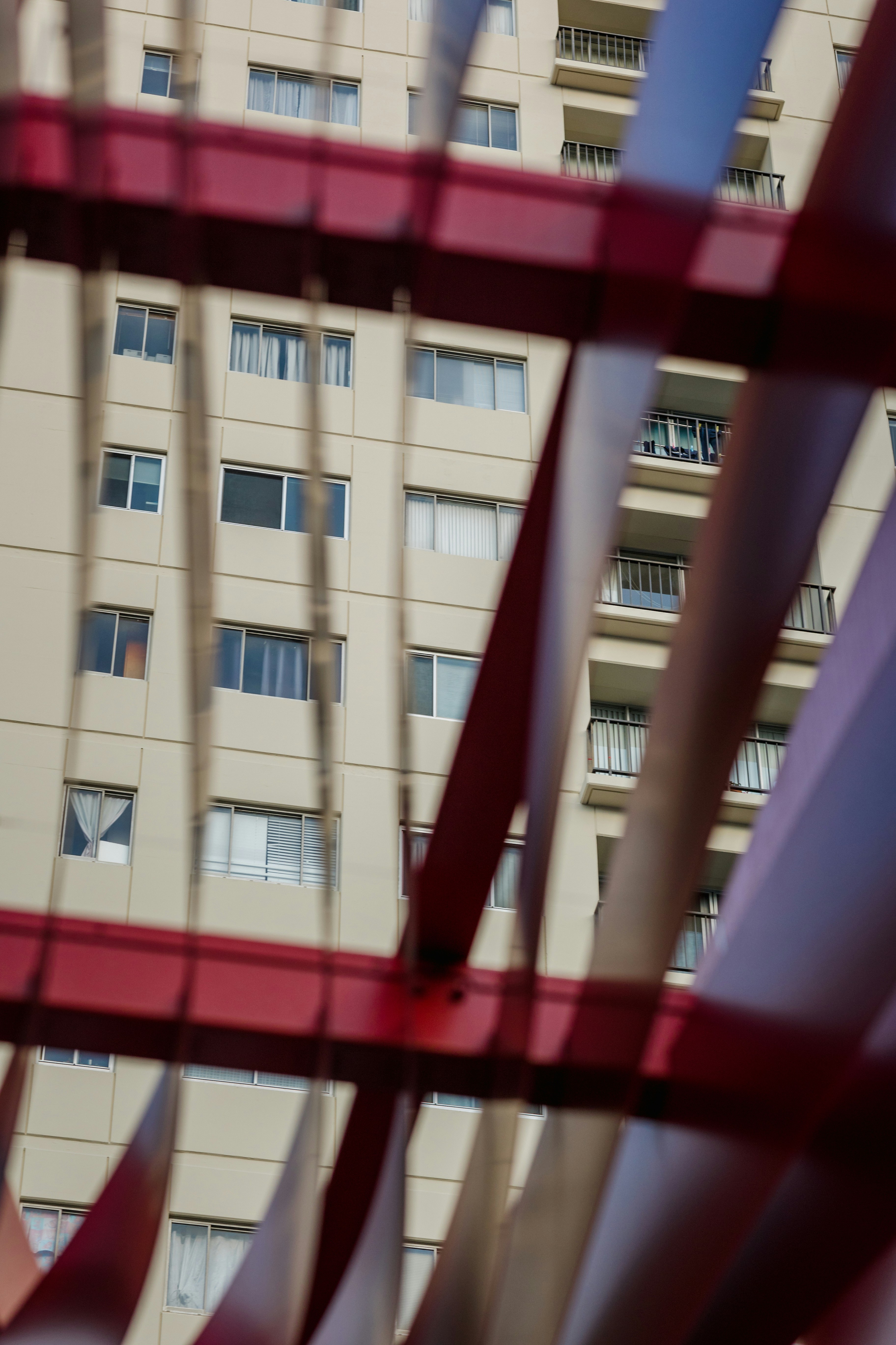 a tall building with a red metal structure in front of it