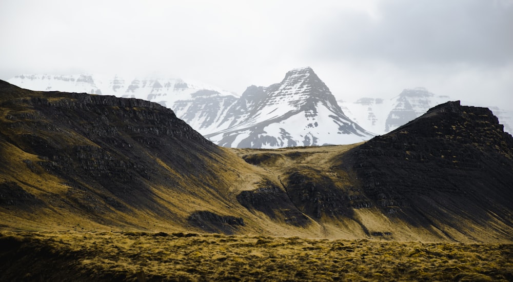 a mountain range with a snow covered mountain in the background