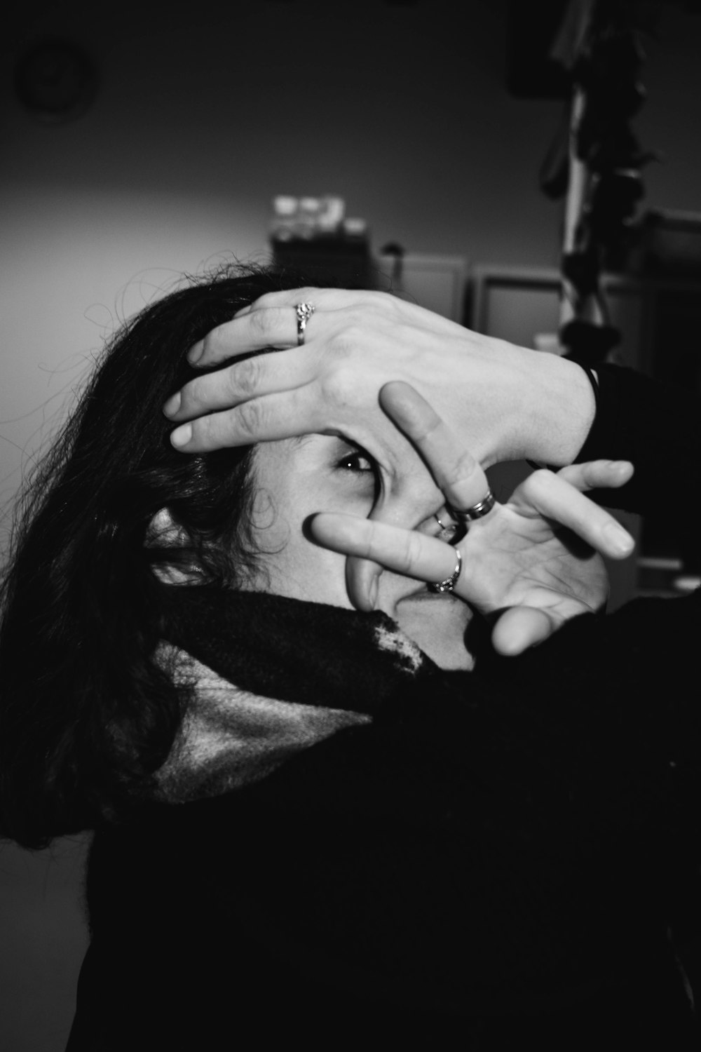 a black and white photo of a woman with her hands on her face