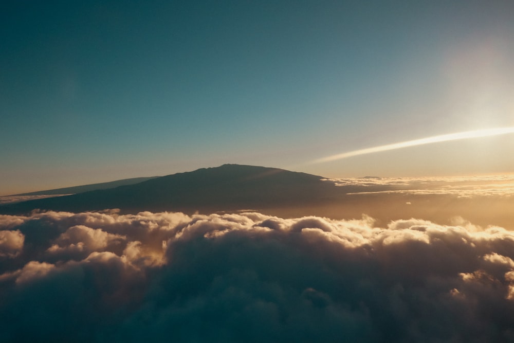 the sun is shining above the clouds in the sky