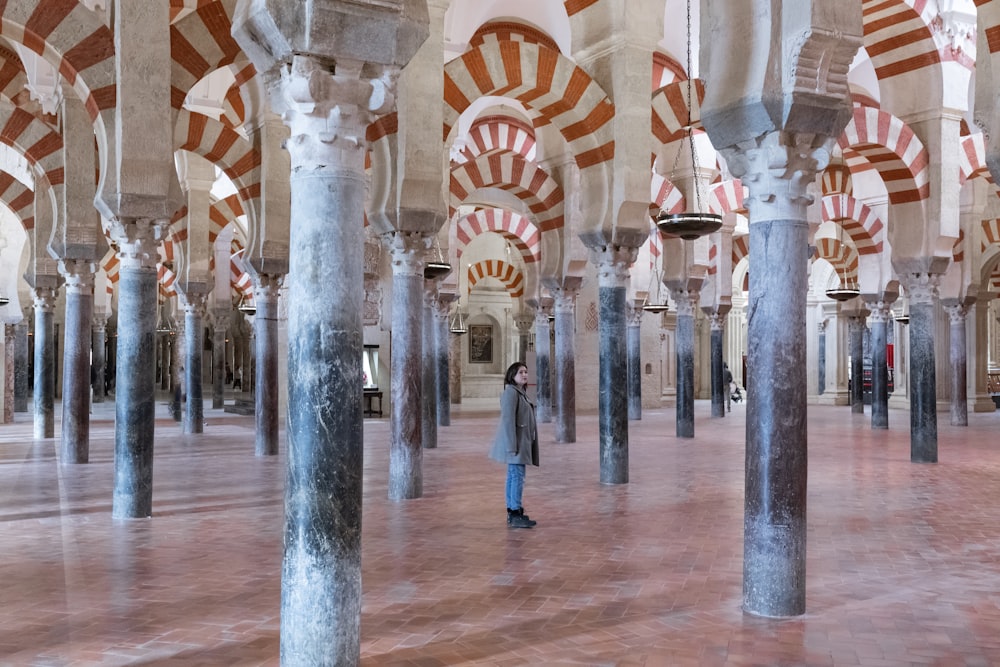 a person standing in a large room with columns