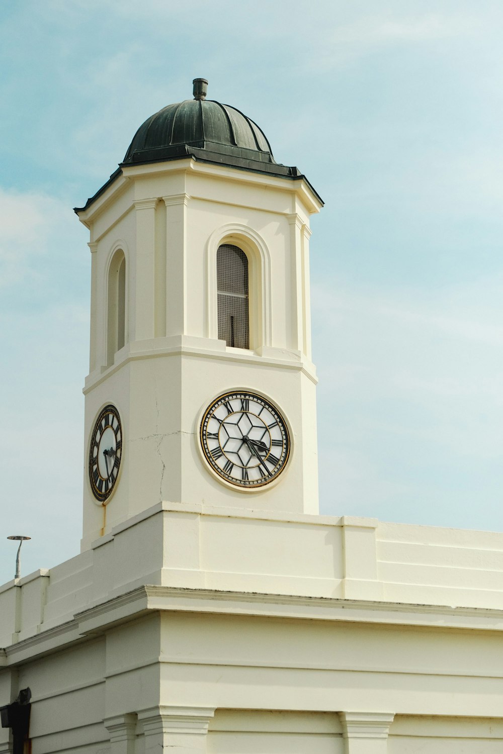 a white clock tower with a sky background
