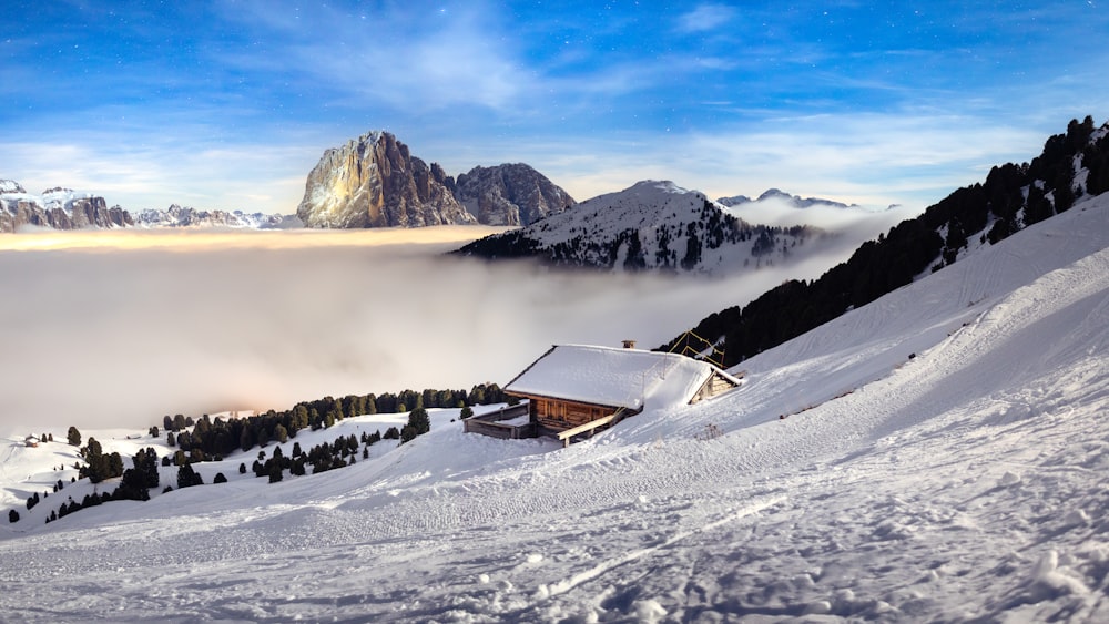 a snowy mountain with a house in the foreground