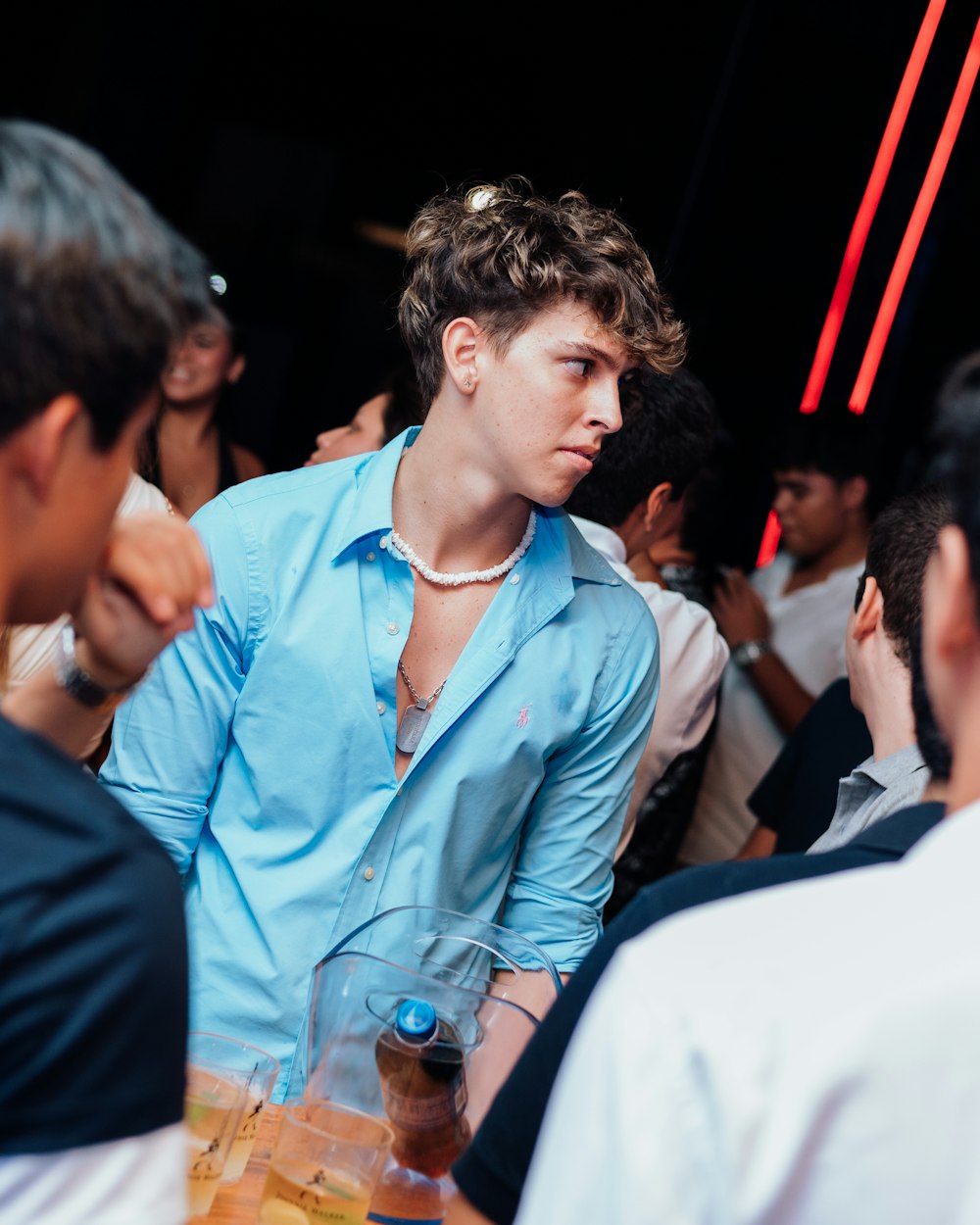 a man in a blue shirt standing in front of a group of people