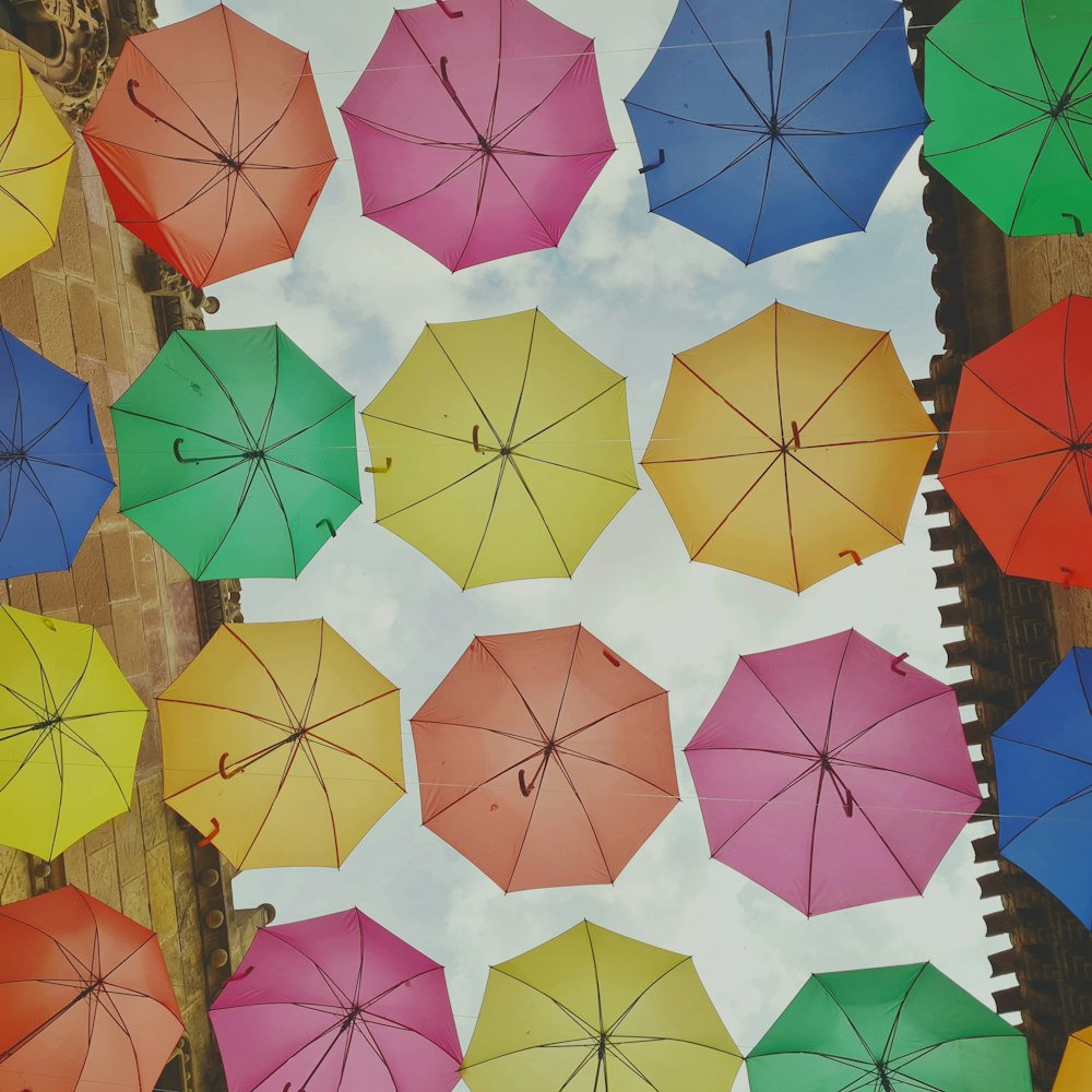 a bunch of colorful umbrellas hanging up in the air