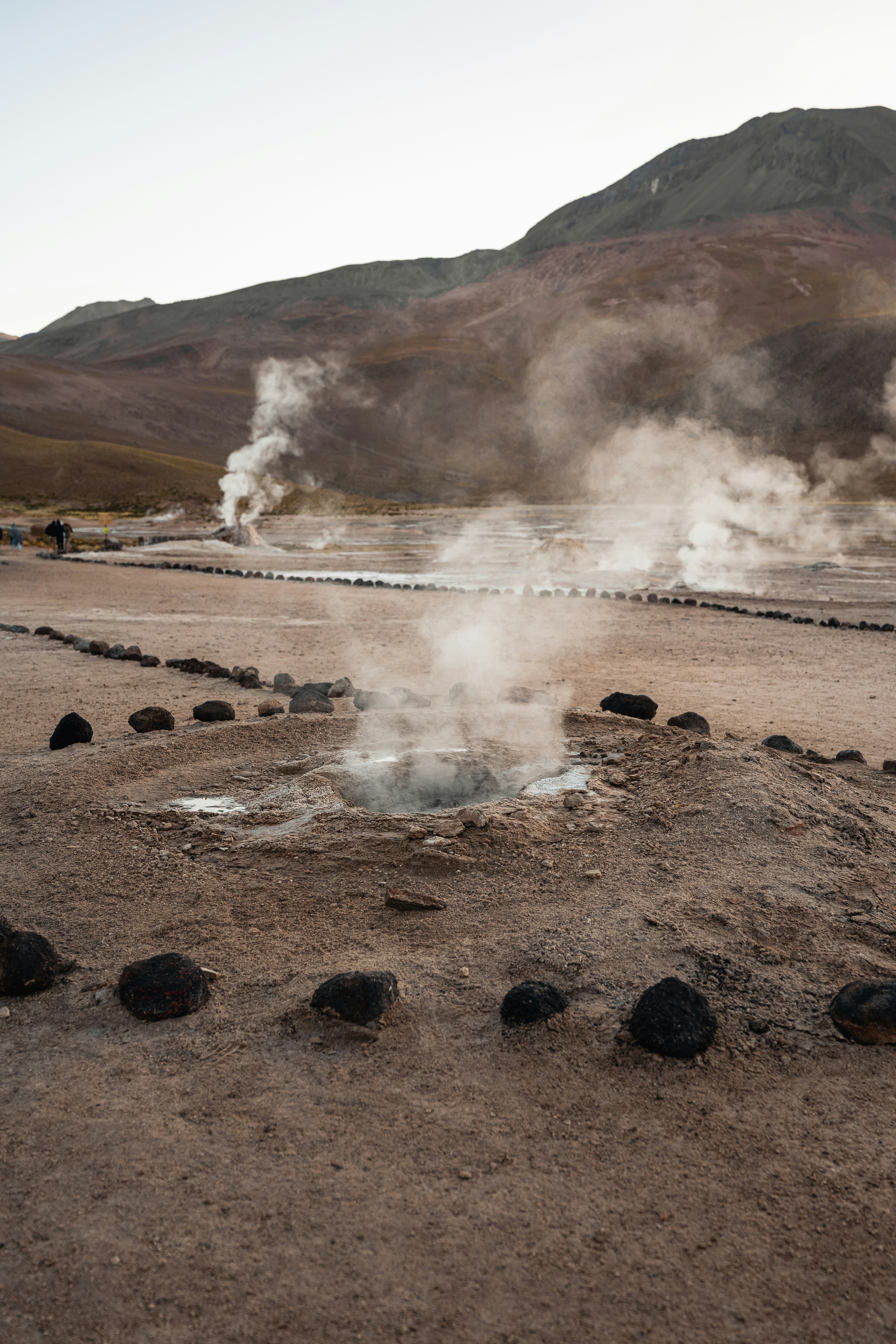 steam rises from a pool of water in the desert