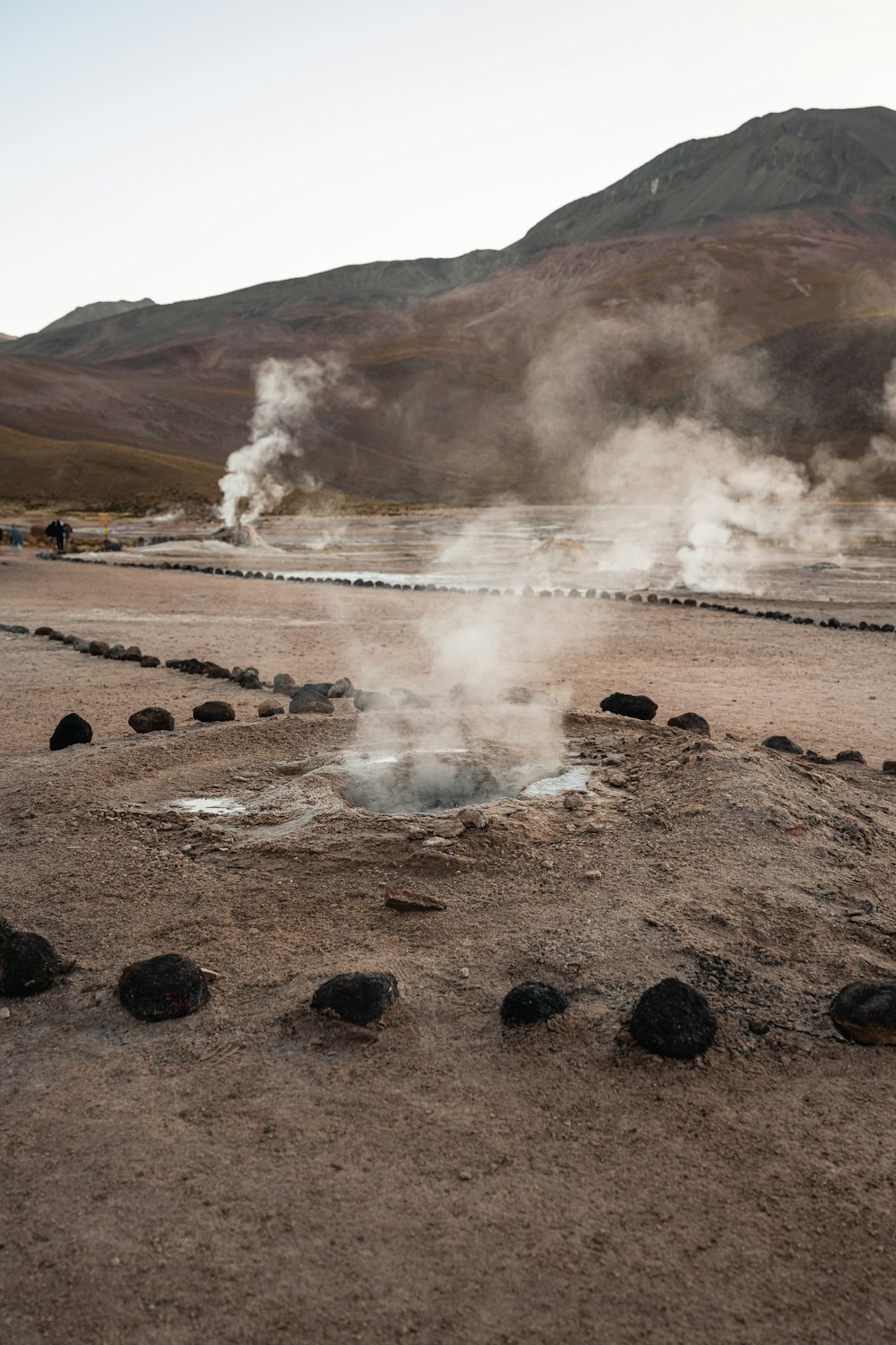 steam rises from a pool of water in the desert