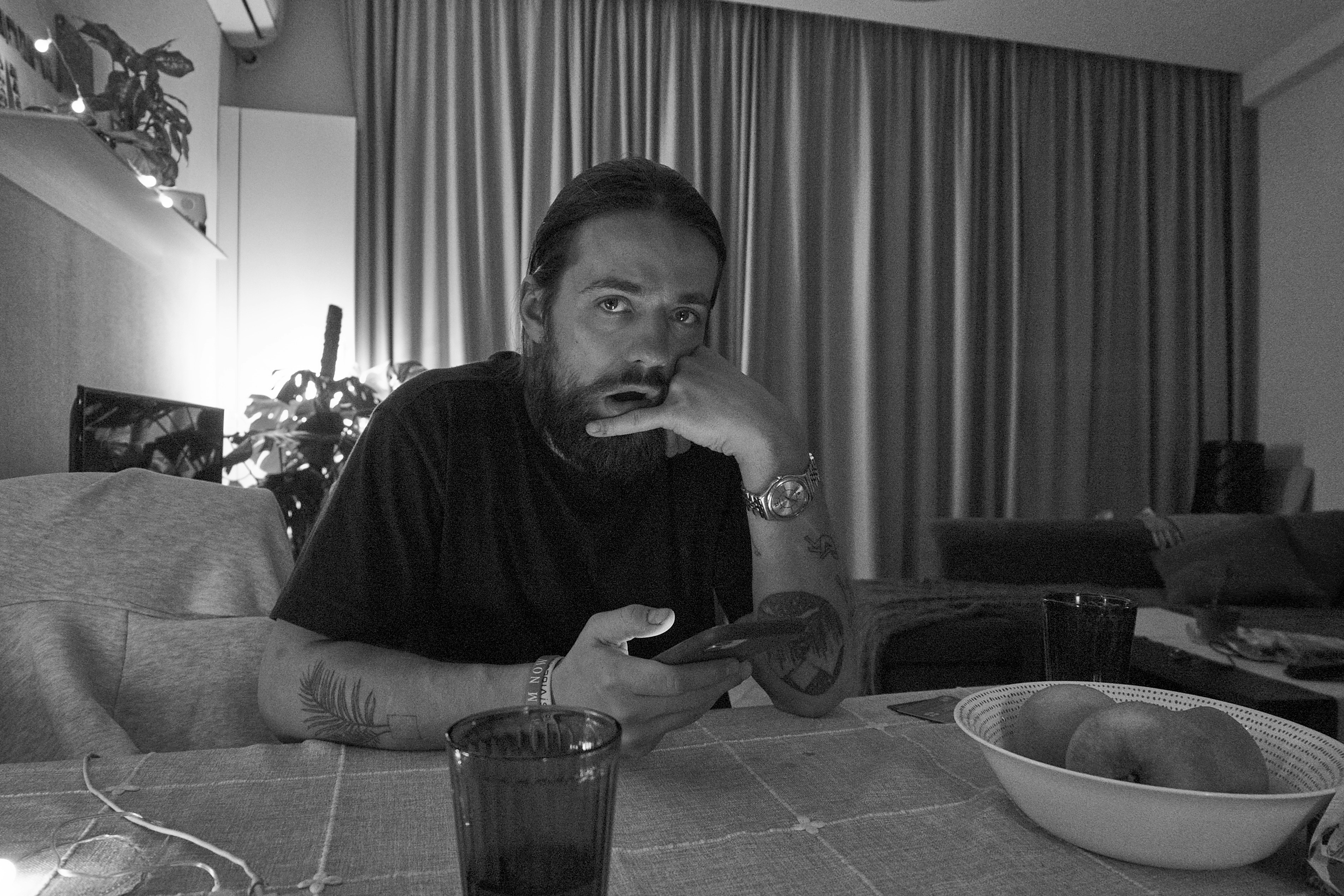 a man sitting at a table in front of a bowl of fruit
