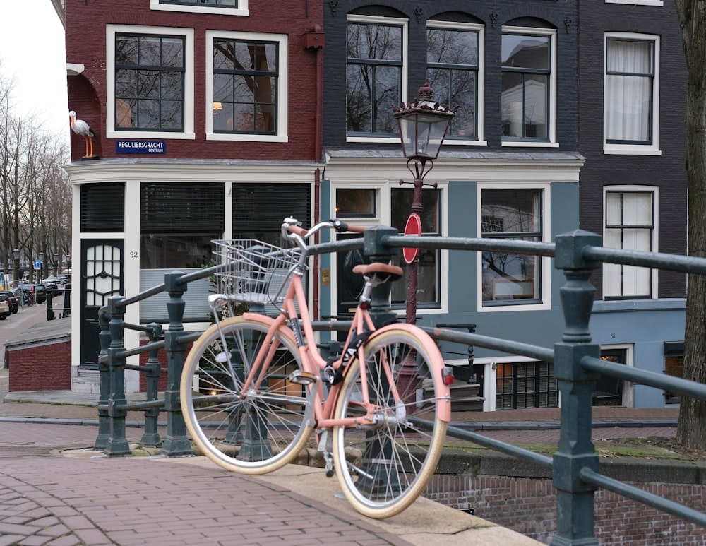 a pink bike parked next to a parking meter