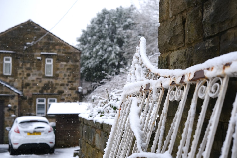 a snow covered bench next to a brick building