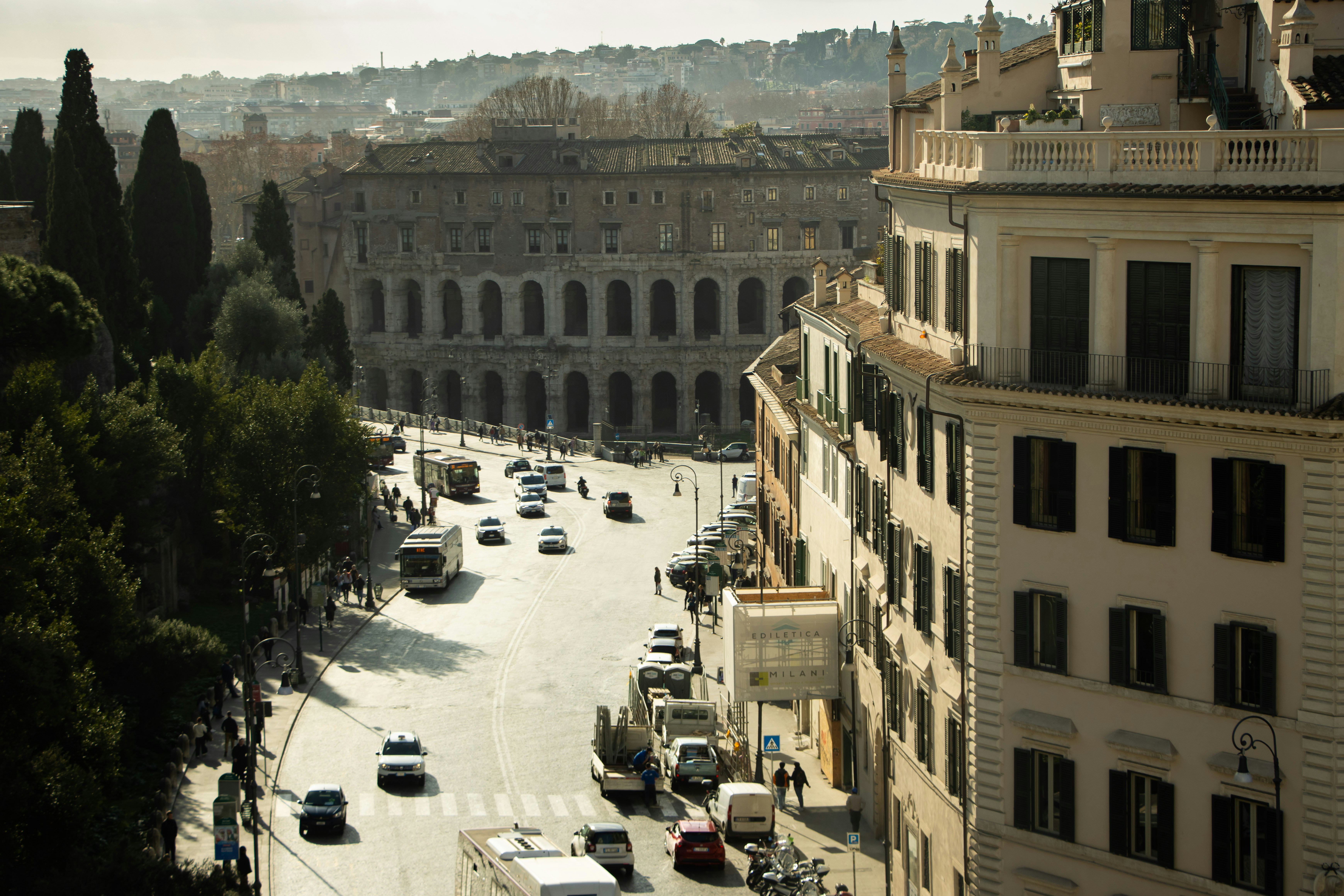 a city street filled with lots of traffic next to tall buildings