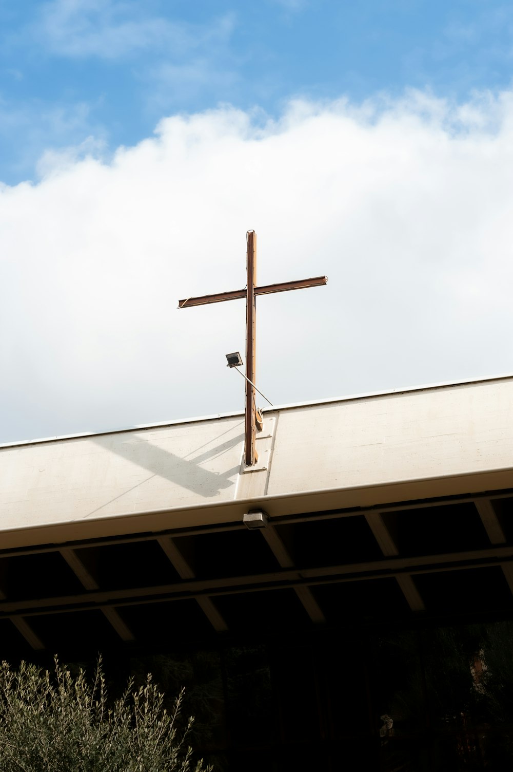 a cross on top of a building with a sky background