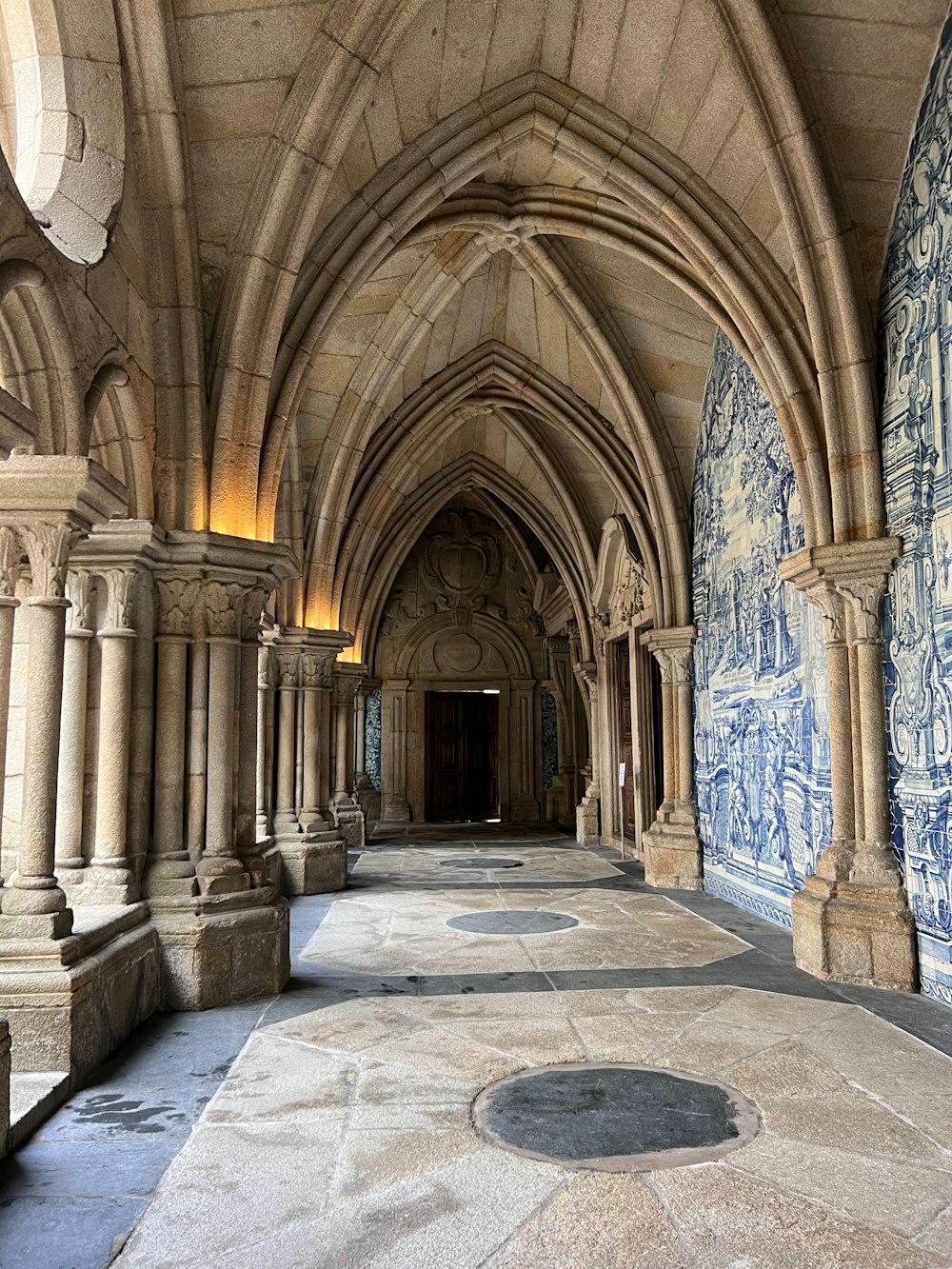 a long hallway with blue and white tiles on the walls