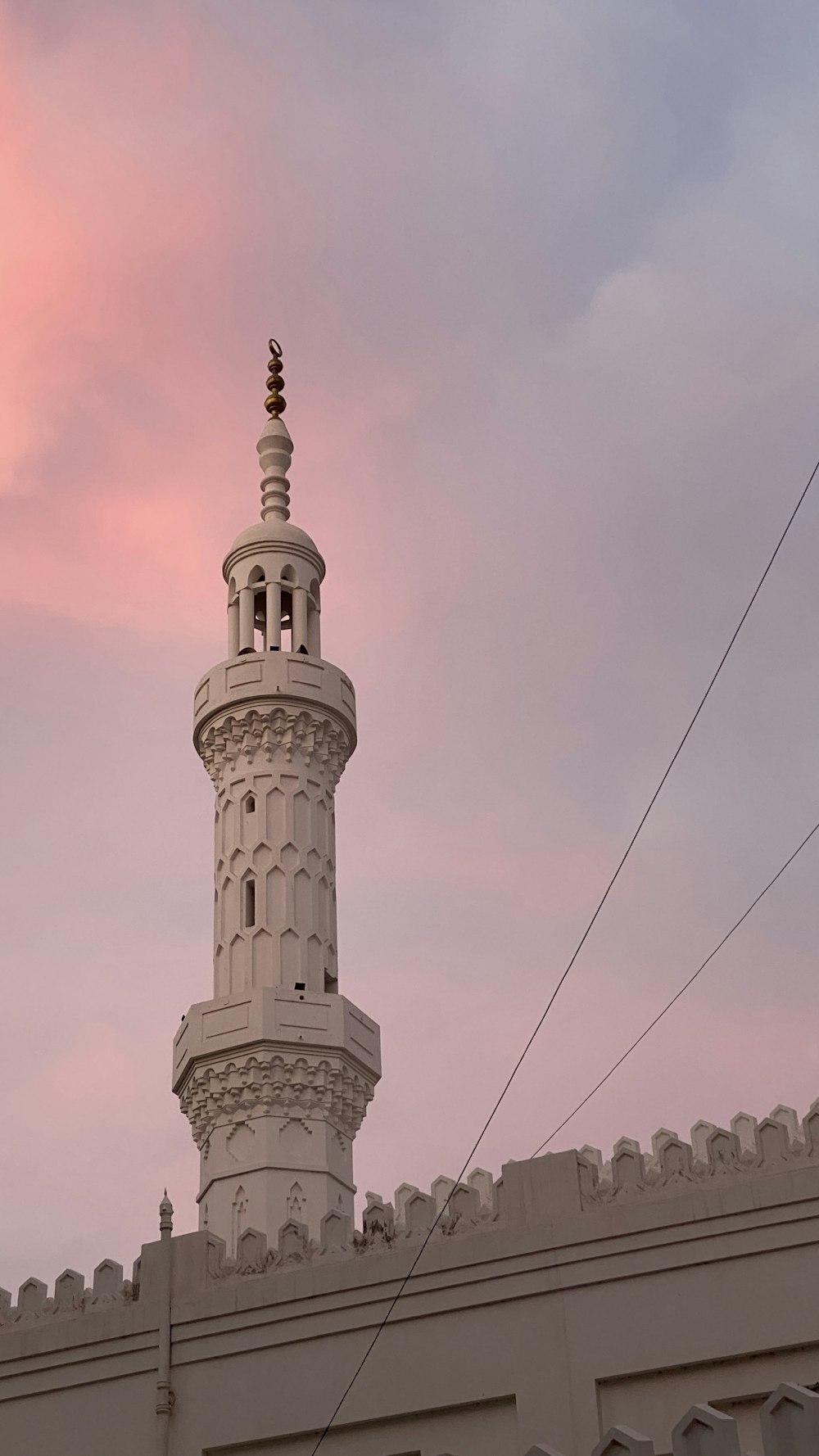 a tall white tower with a clock on it's side