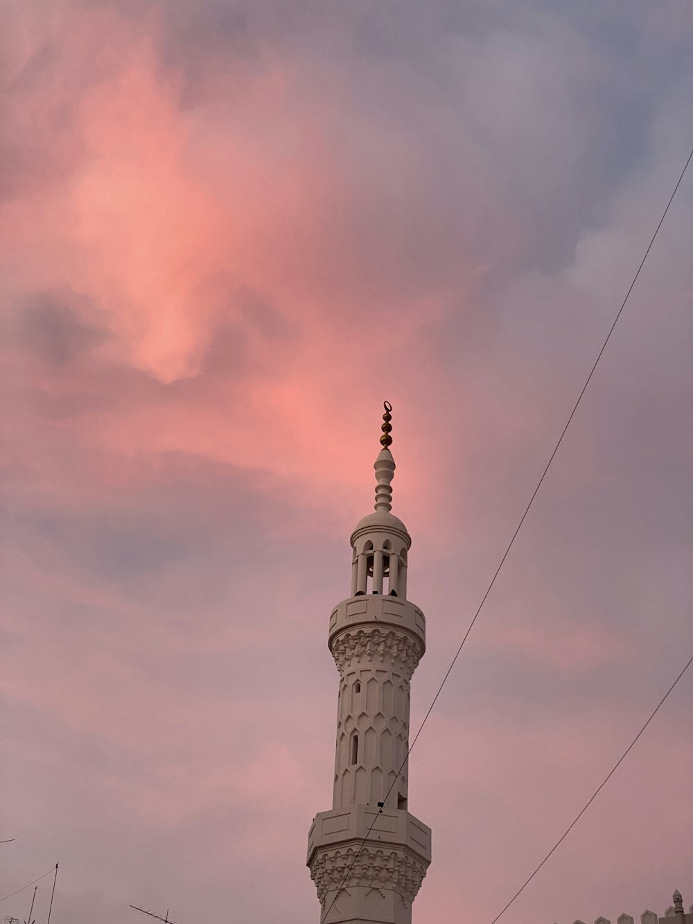 a tall white tower with a clock on it's side