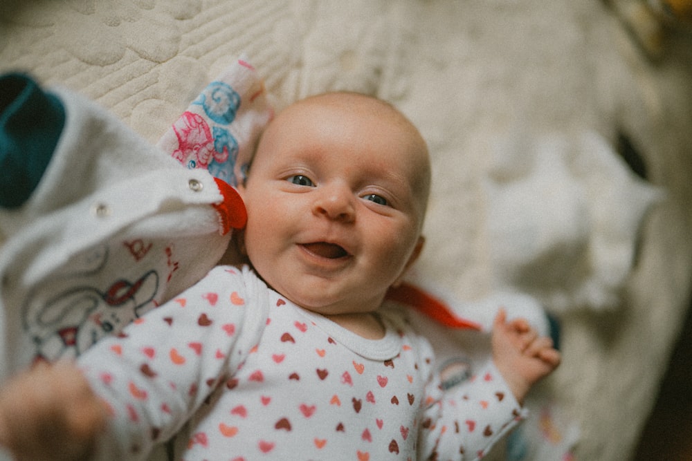 ein Baby, das auf dem Rücken auf einem Bett liegt