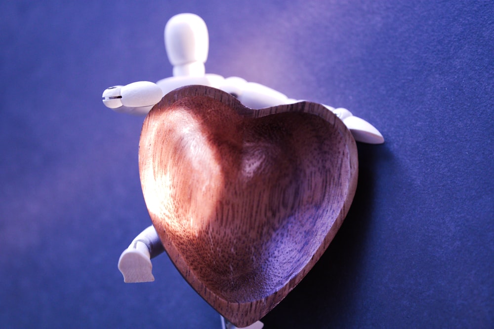 a wooden heart shaped object on a blue surface