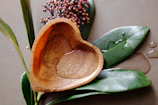 a wooden spoon sitting on top of a leafy plant