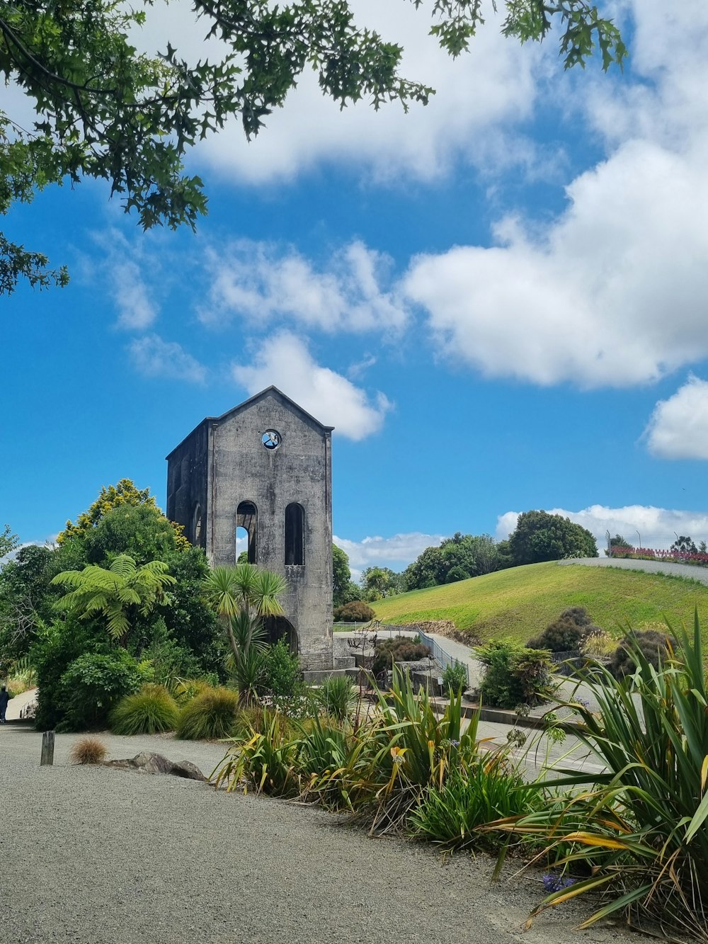 an old church sits on a hill surrounded by greenery