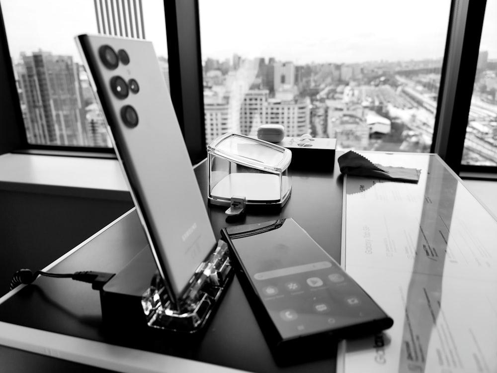 uma mesa com um celular e um controle remoto sobre ele