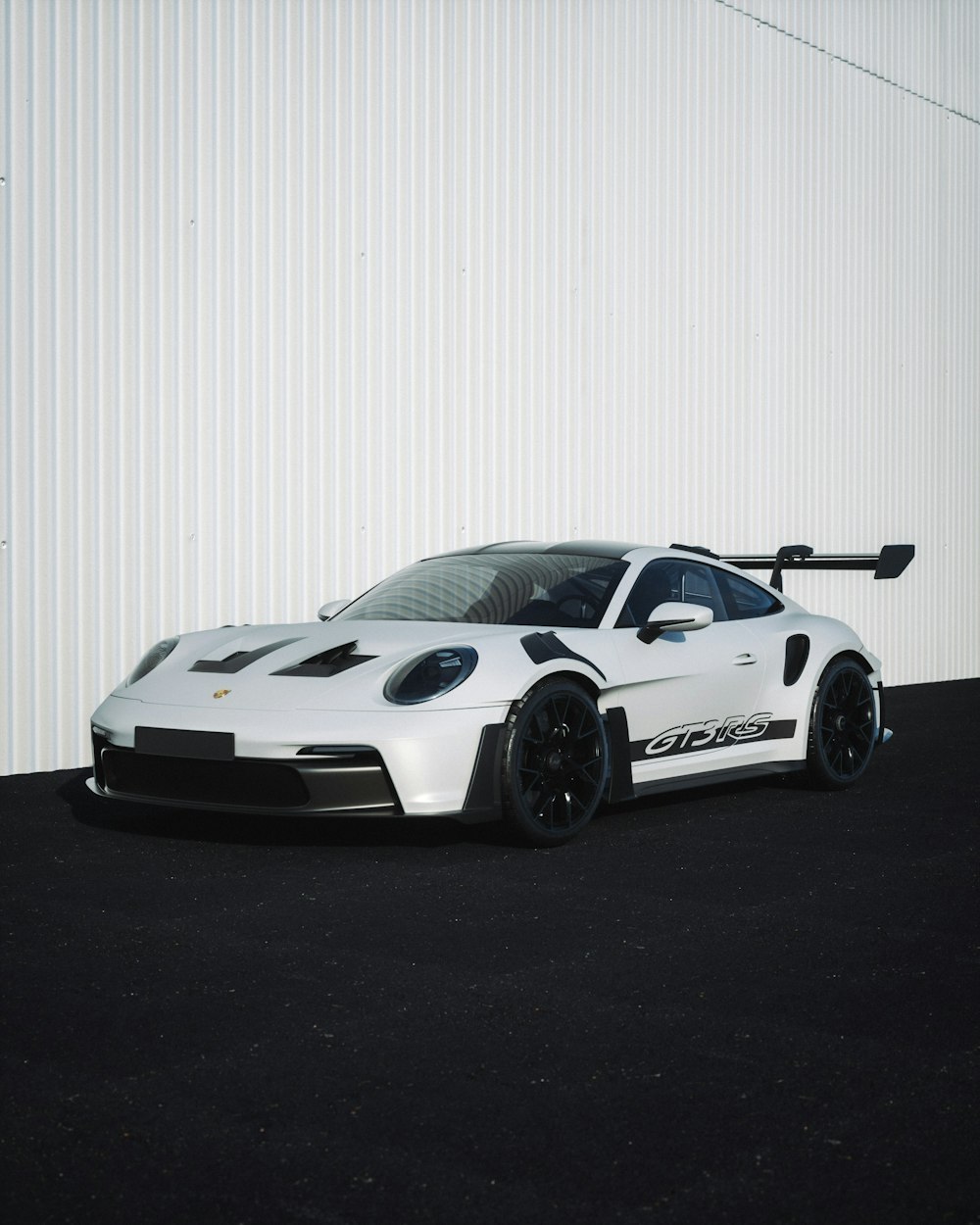 um carro esportivo branco estacionado em frente a um prédio