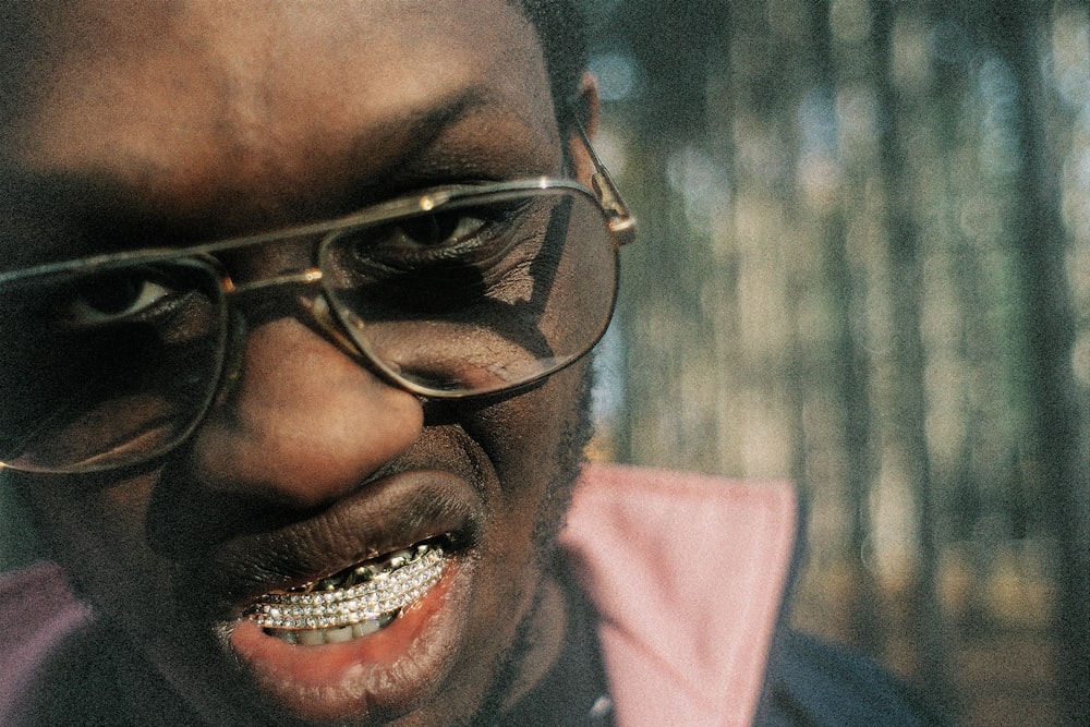 a man wearing glasses and a pink shirt