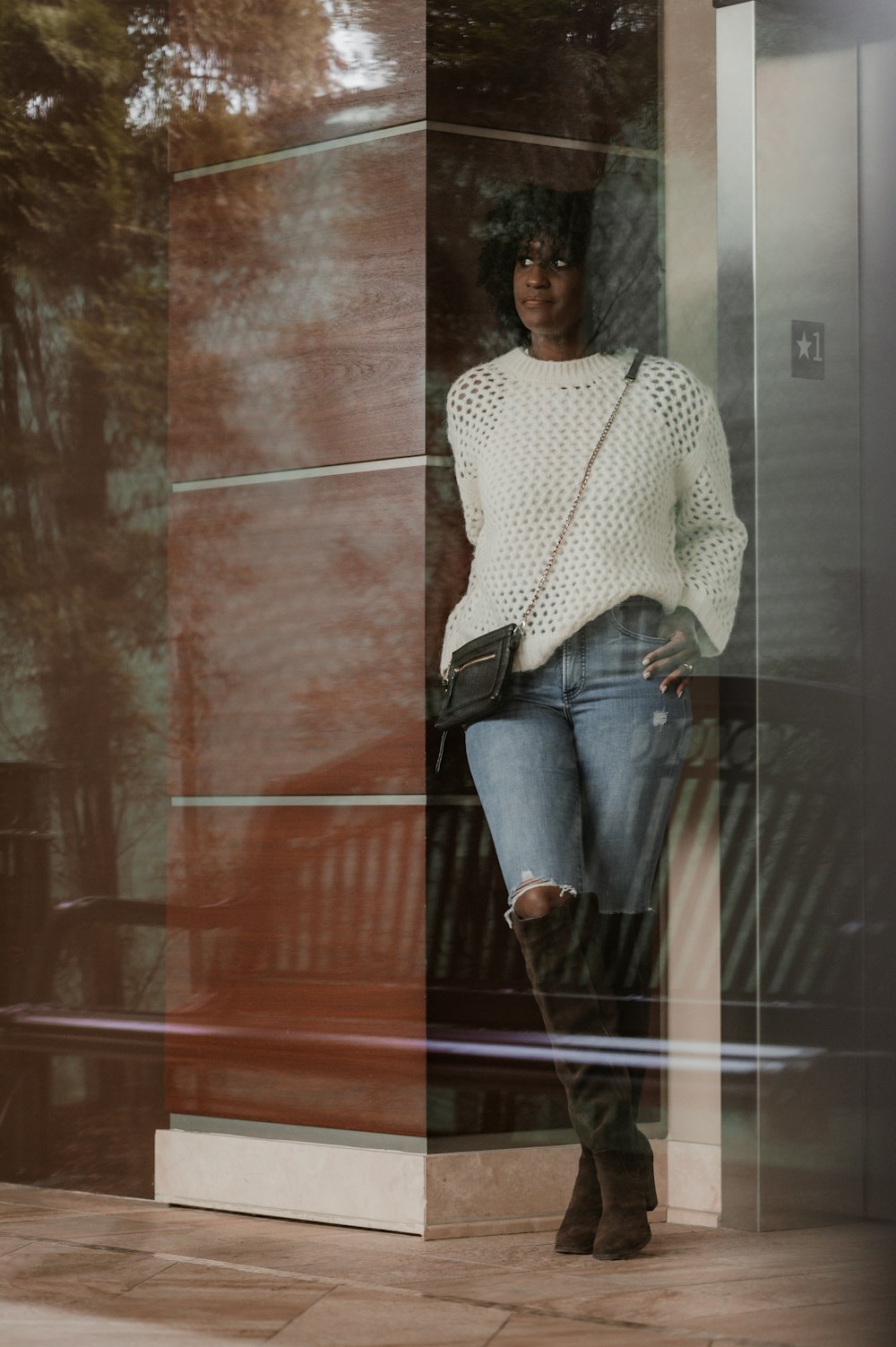 a woman standing in front of a glass wall