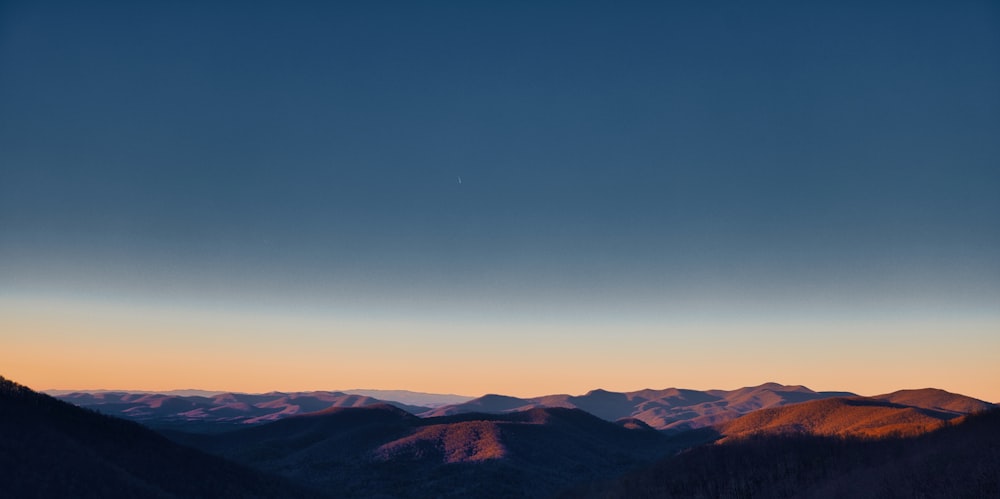 une vue d’une chaîne de montagnes au coucher du soleil