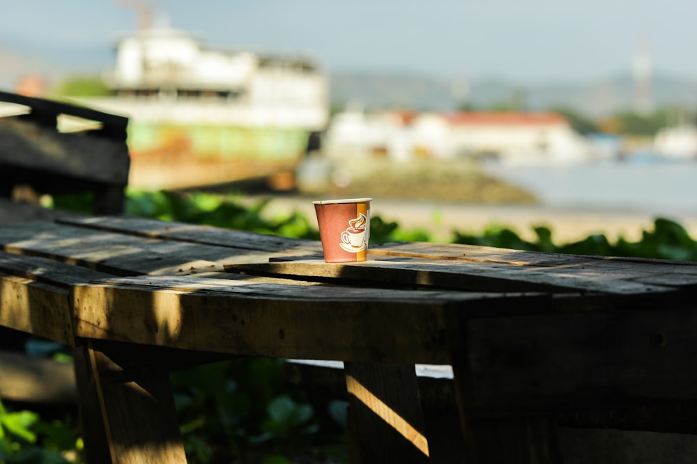 a cup of coffee sitting on top of a wooden table