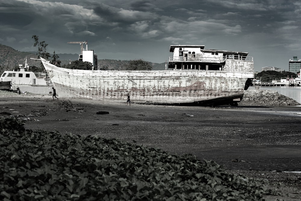 a boat sitting on top of a beach next to the ocean