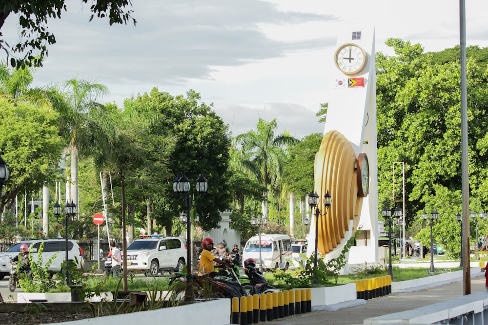 a group of people sitting on a bench next to a clock