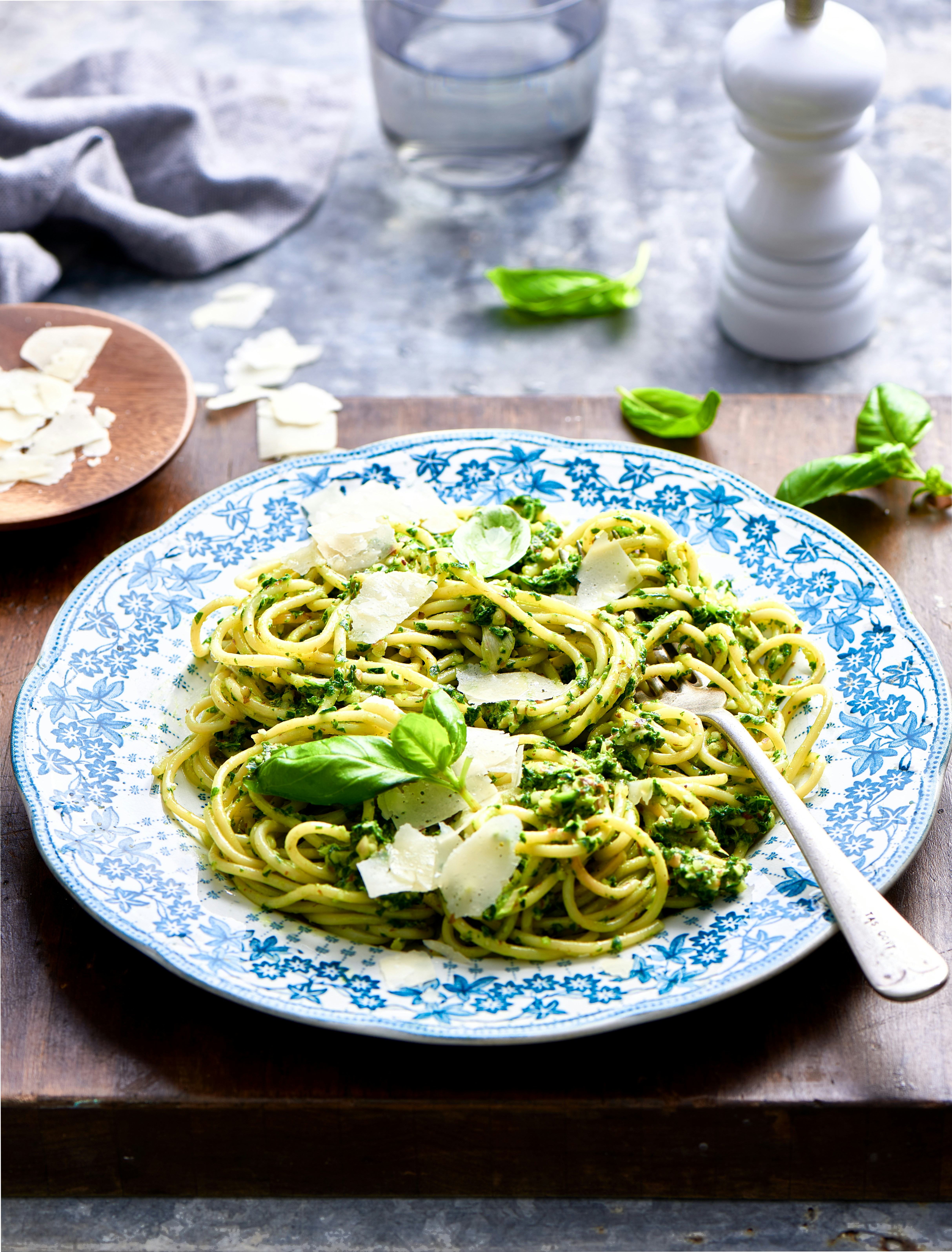 a plate of pasta with broccoli and parmesan cheese