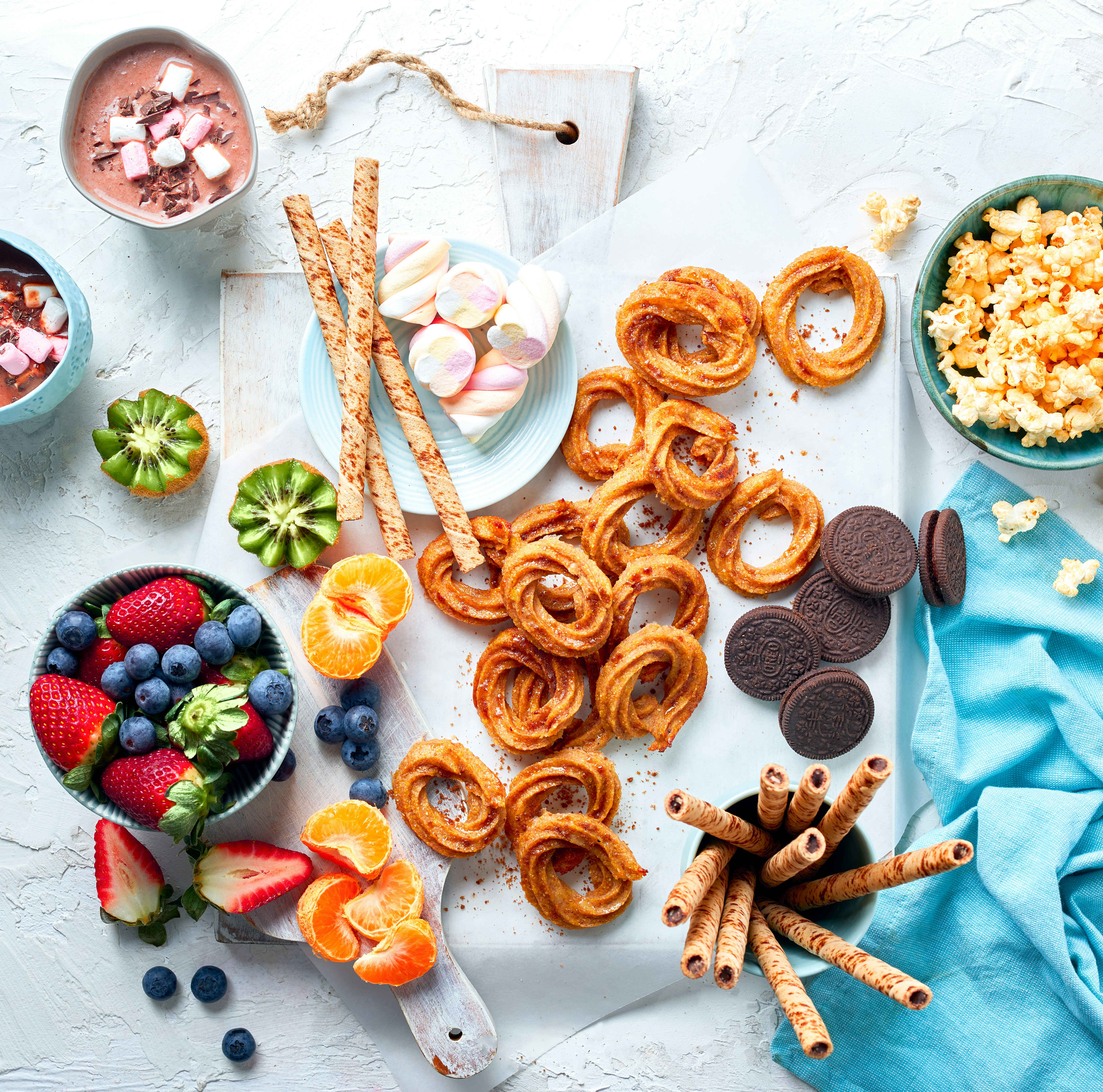 a table topped with bowls of fruit and snacks