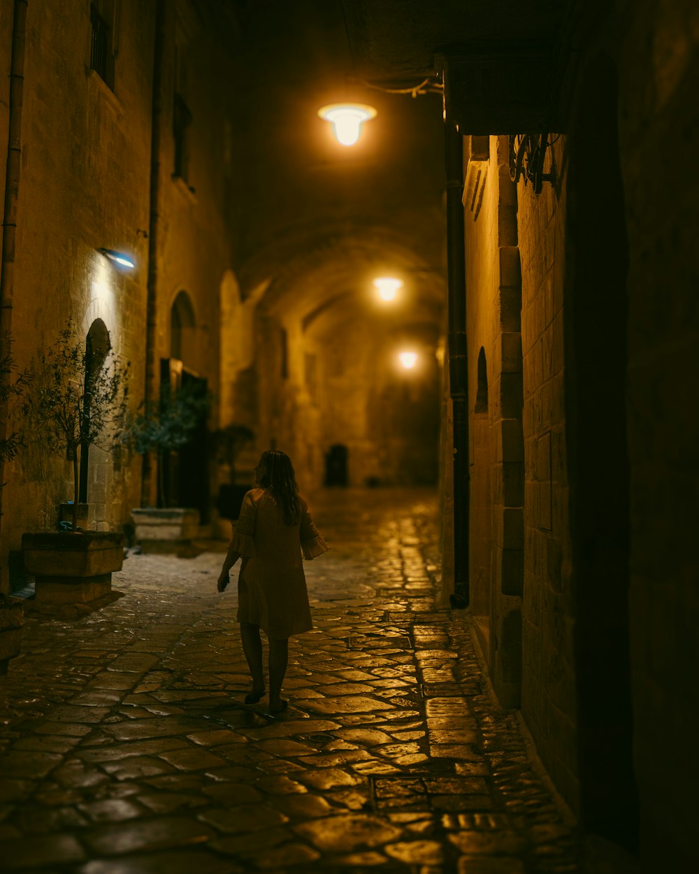 a woman walking down a dark alley way