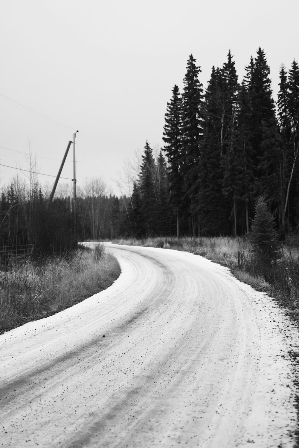 a black and white photo of a snow covered road