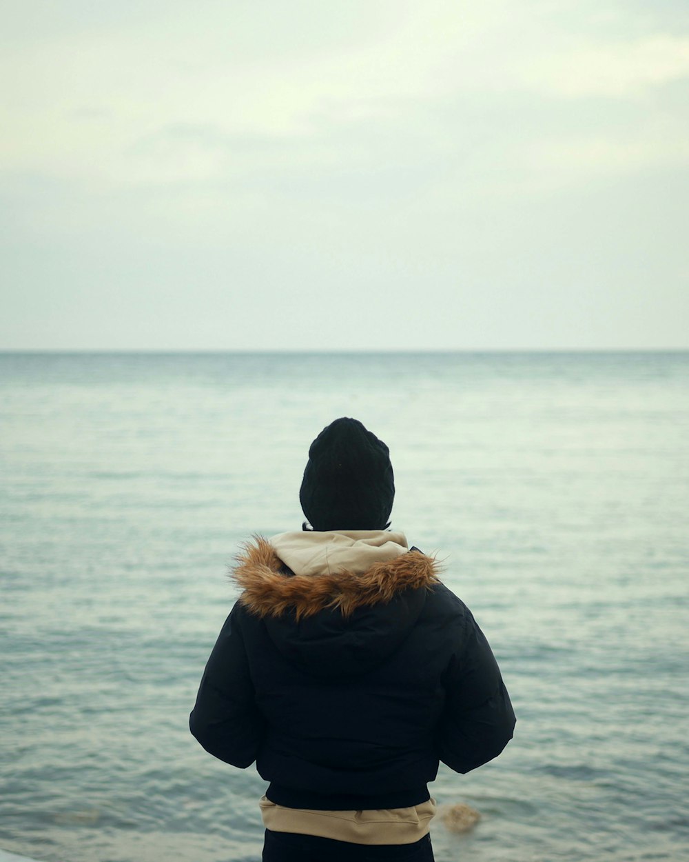 a person standing on a beach looking out at the ocean