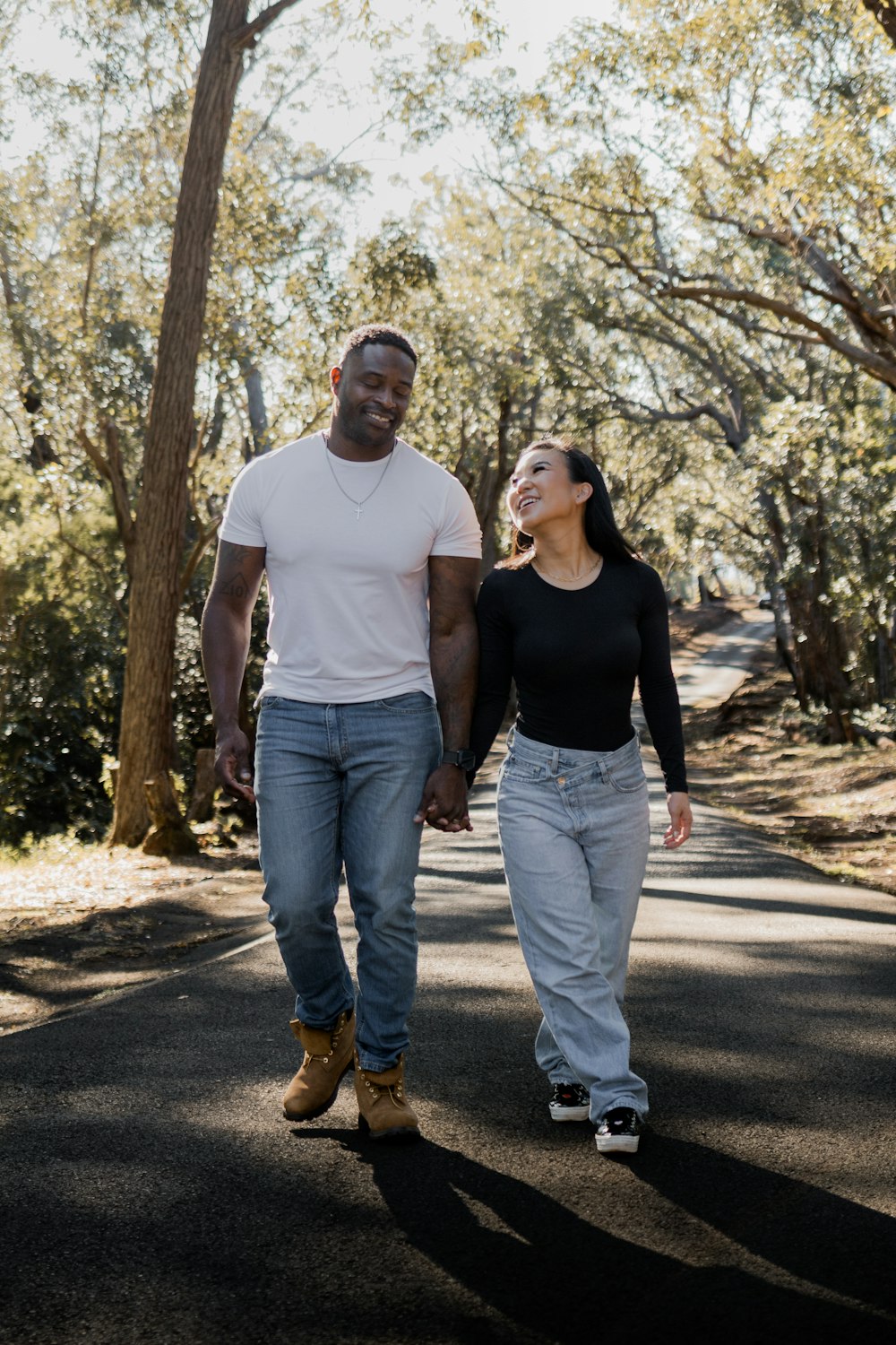 a man and a woman walking down a road holding hands