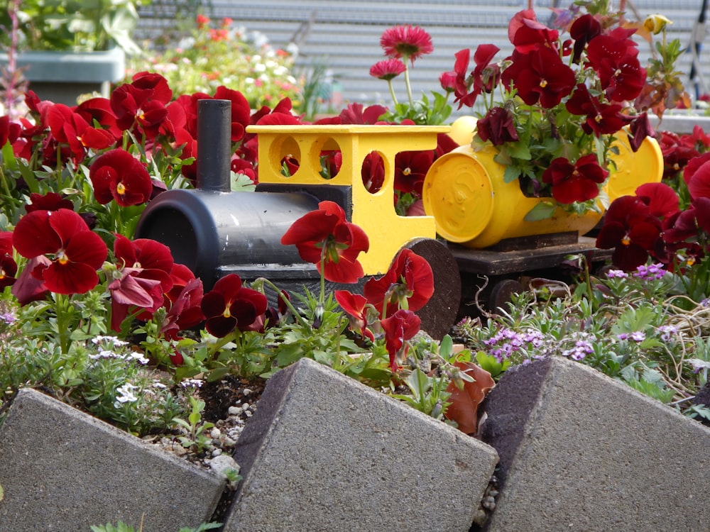 a toy train with flowers in the background