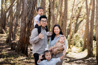 a family posing for a picture in the woods