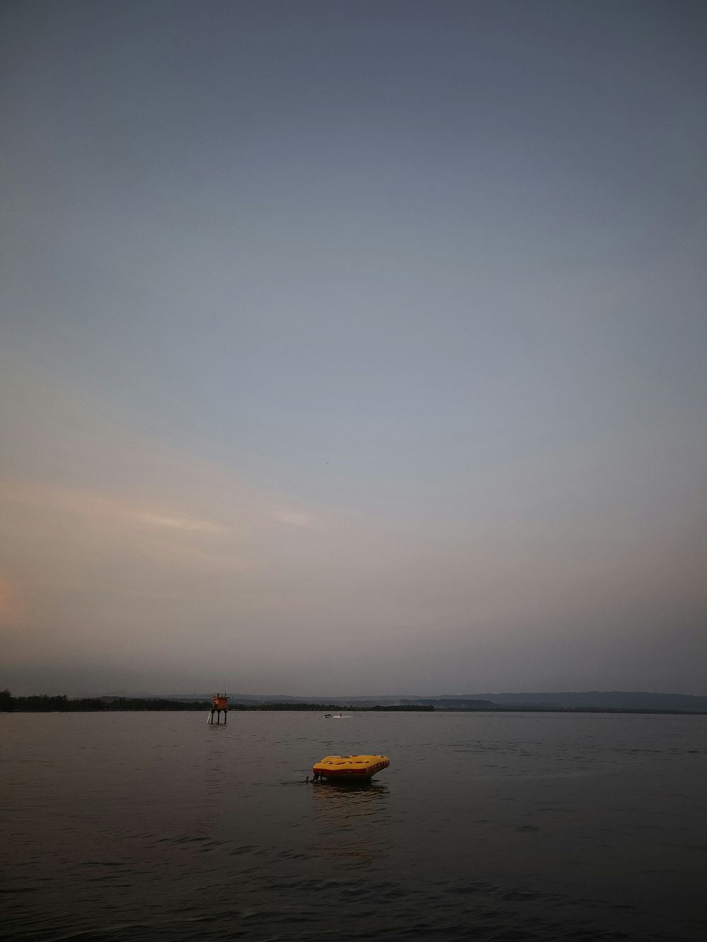 a small boat floating on top of a large body of water