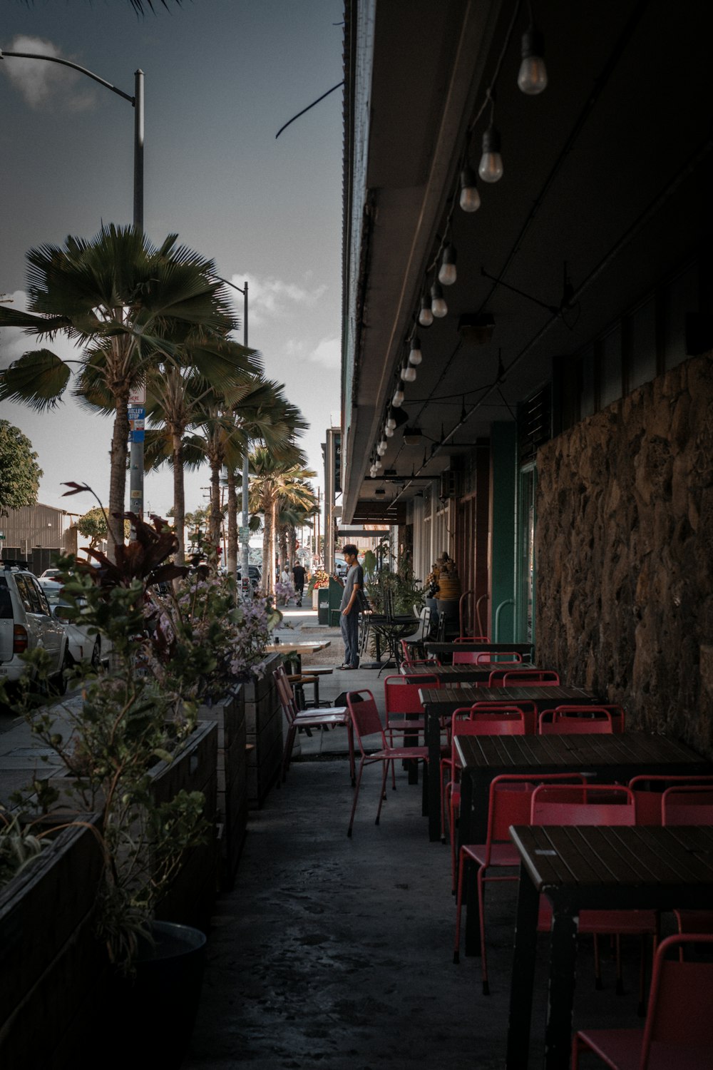 a row of red chairs sitting on top of a sidewalk