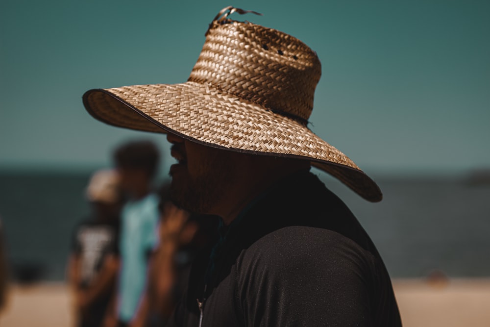 a man wearing a straw hat on the beach
