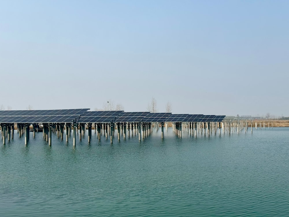 a row of solar panels sitting on top of a body of water