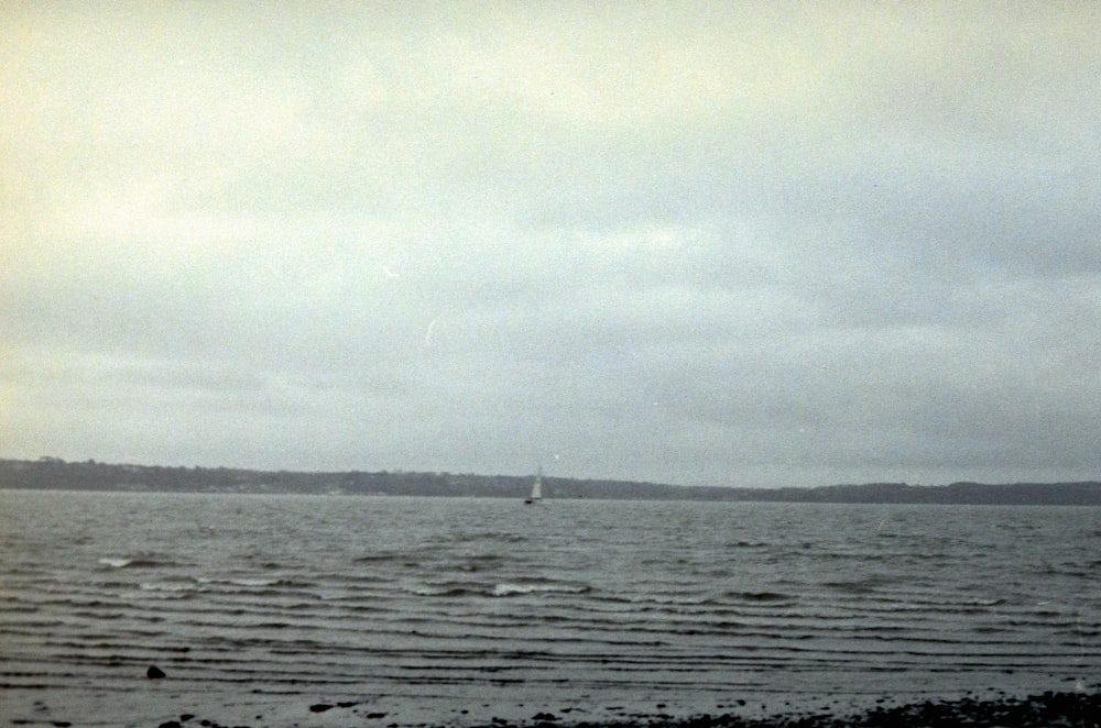 a sailboat is out on the water on a cloudy day