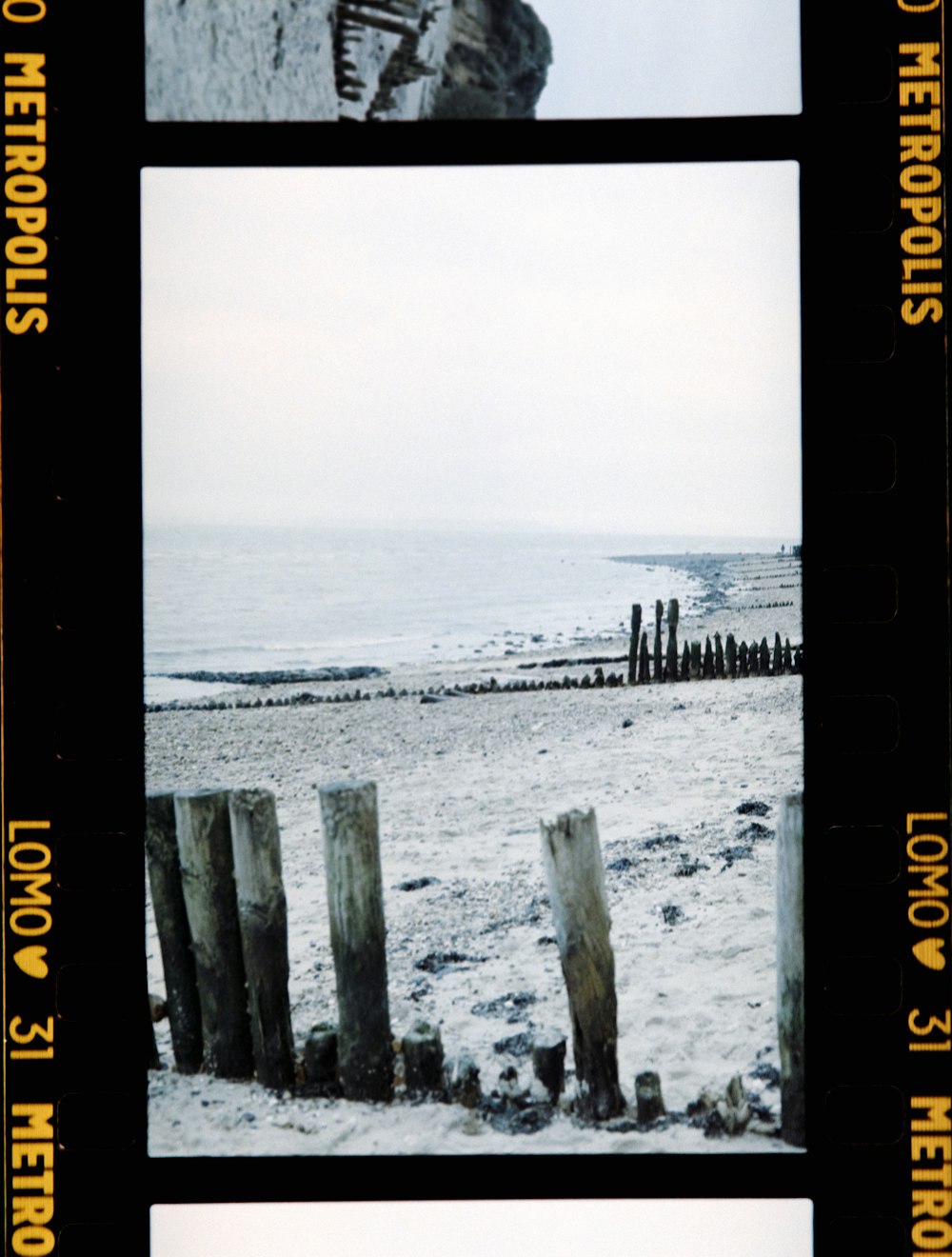 a polaroid picture of a person standing on a beach