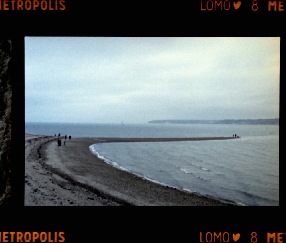 a picture of a beach with people walking on it