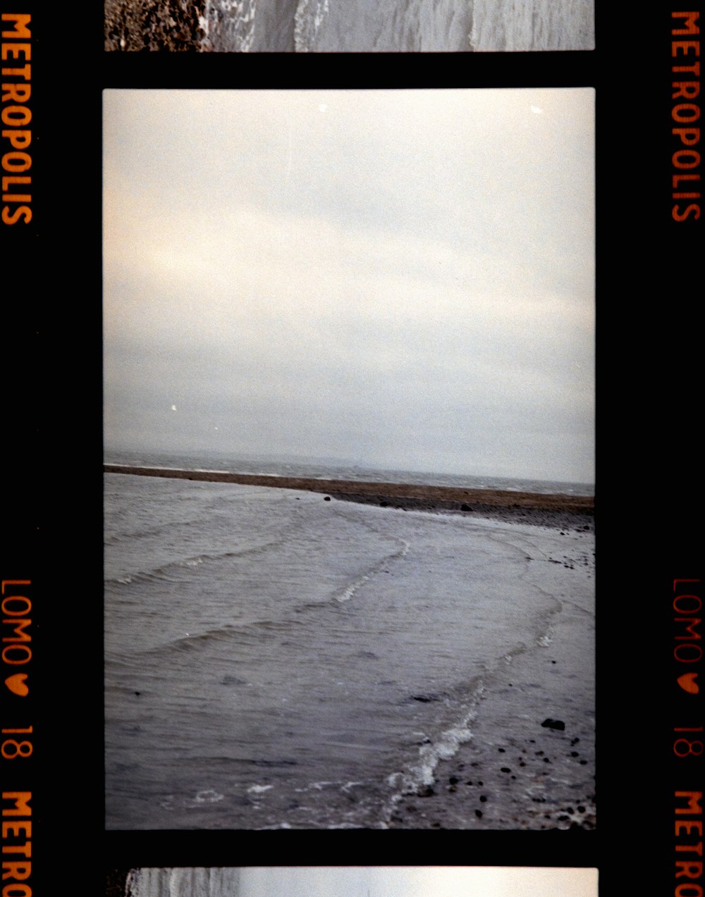 a polaroid picture of a beach and a body of water