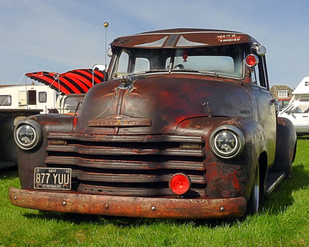 an old truck is parked in the grass